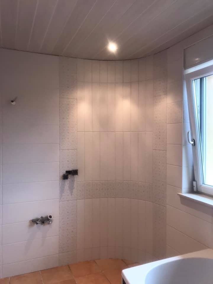 Douche au mur arrondi en cours de carrelage